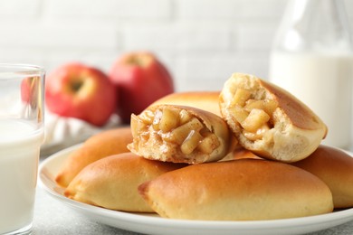 Photo of Tasty baked patties with apples and milk on table, closeup