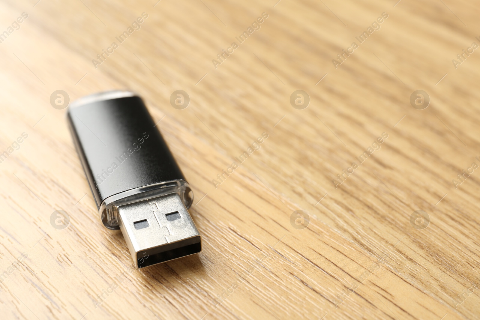 One flash drive on wooden background, closeup. Space for text Photo of One flash drive on wooden background, closeup. Space for text