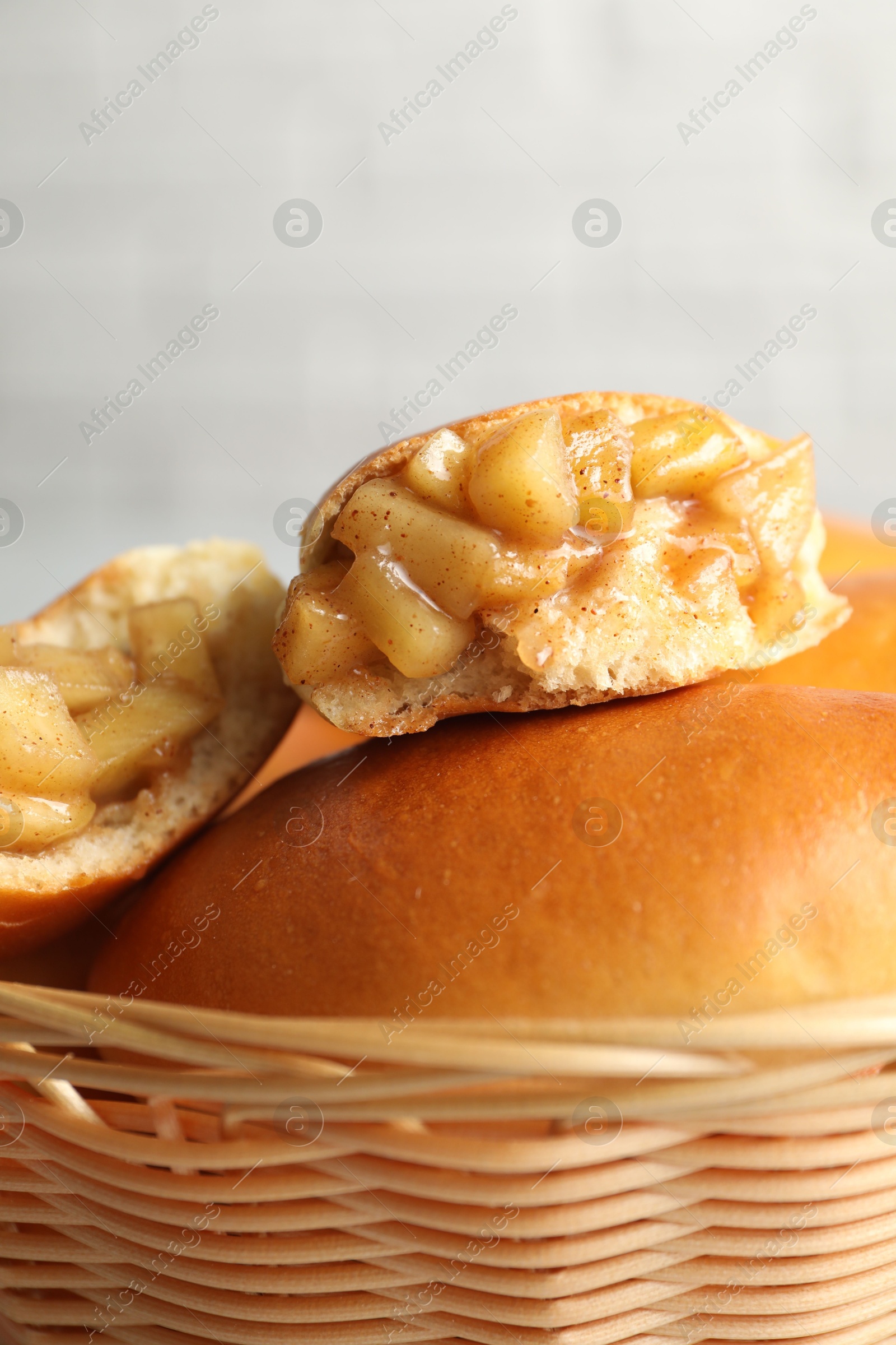 Tasty baked patties in wicker basket on blurred background, closeup Photo of Tasty baked patties in wicker basket on blurred background, closeup