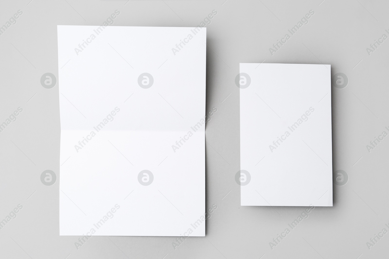 Photo of Blank greeting cards on light background, flat lay