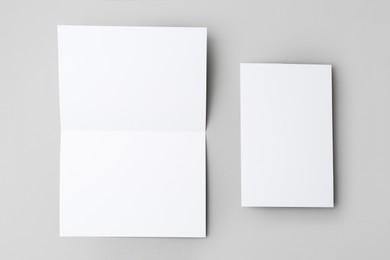 Photo of Blank greeting cards on light background, flat lay