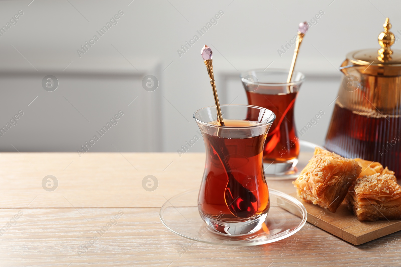 Tasty Turkish tea served with baklava on wooden table. Space for text Photo of Tasty Turkish tea served with baklava on wooden table. Space for text