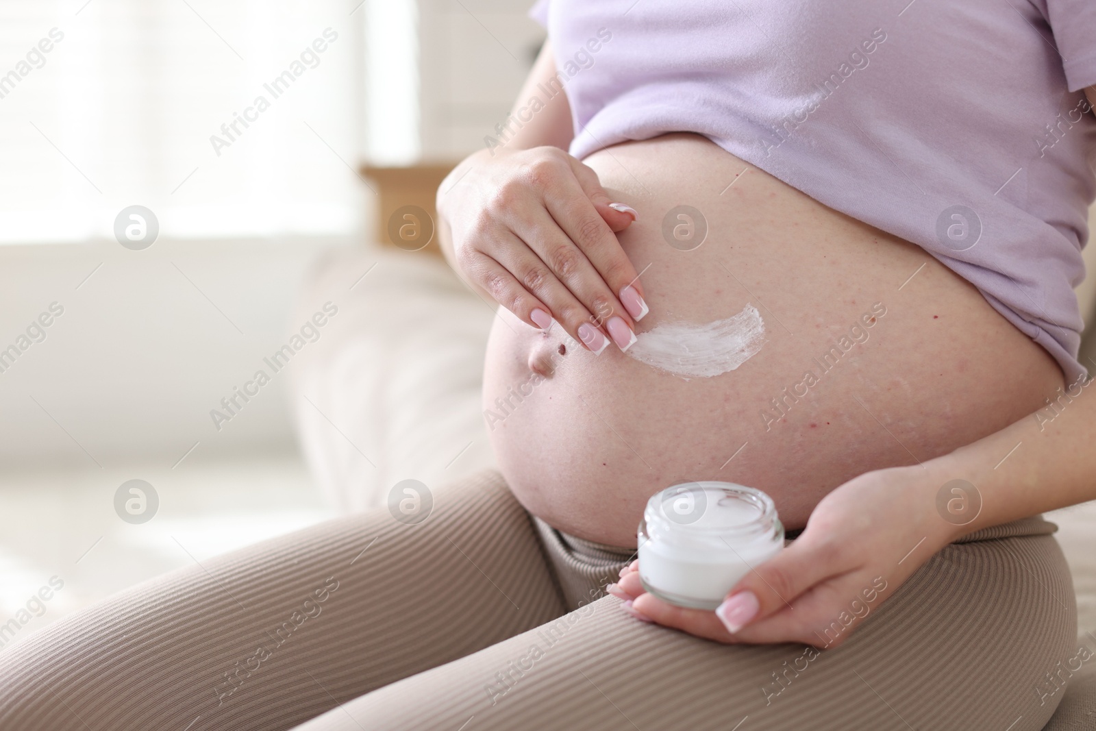 Pregnant woman with jar of cream at home, closeup Photo of Pregnant woman with jar of cream at home, closeup
