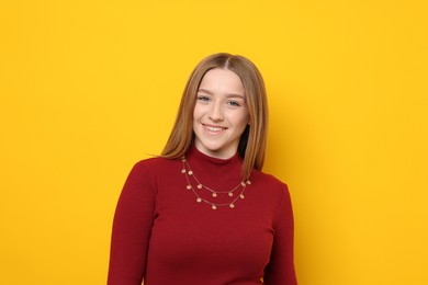 Photo of Portrait of smiling teenage girl on yellow background