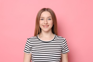 Photo of Portrait of smiling teenage girl on pink background