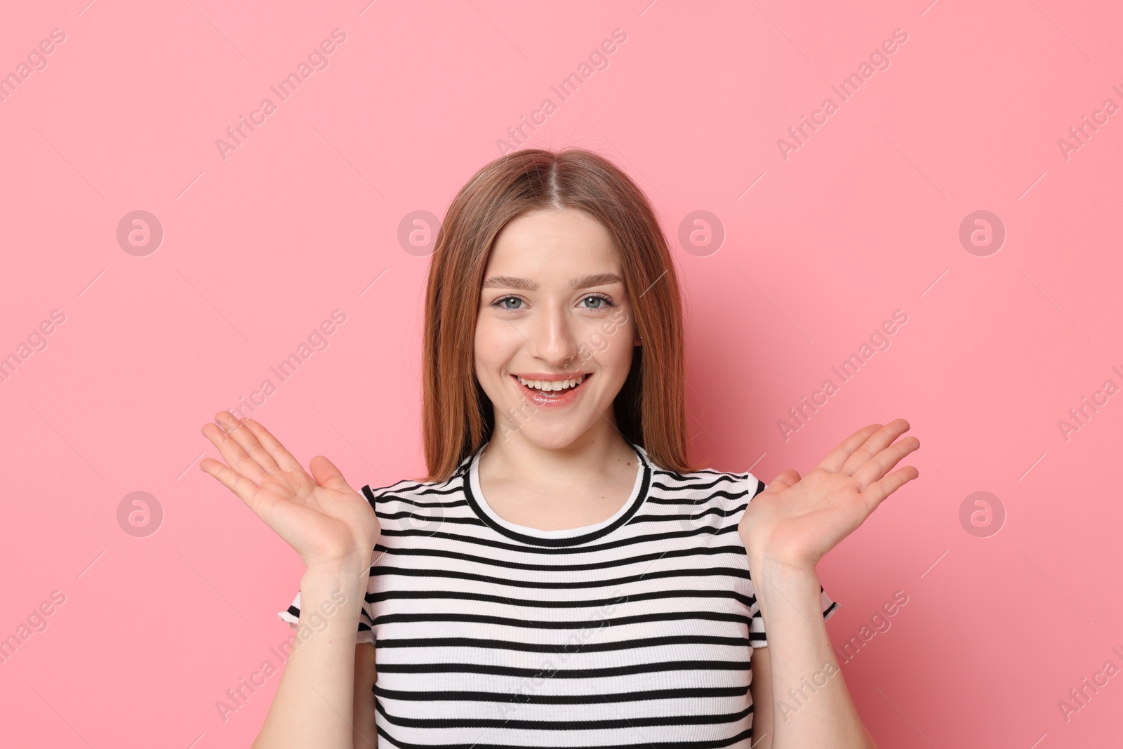 Photo of Portrait of smiling teenage girl on pink background