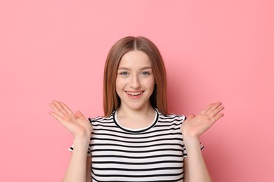 Photo of Portrait of smiling teenage girl on pink background