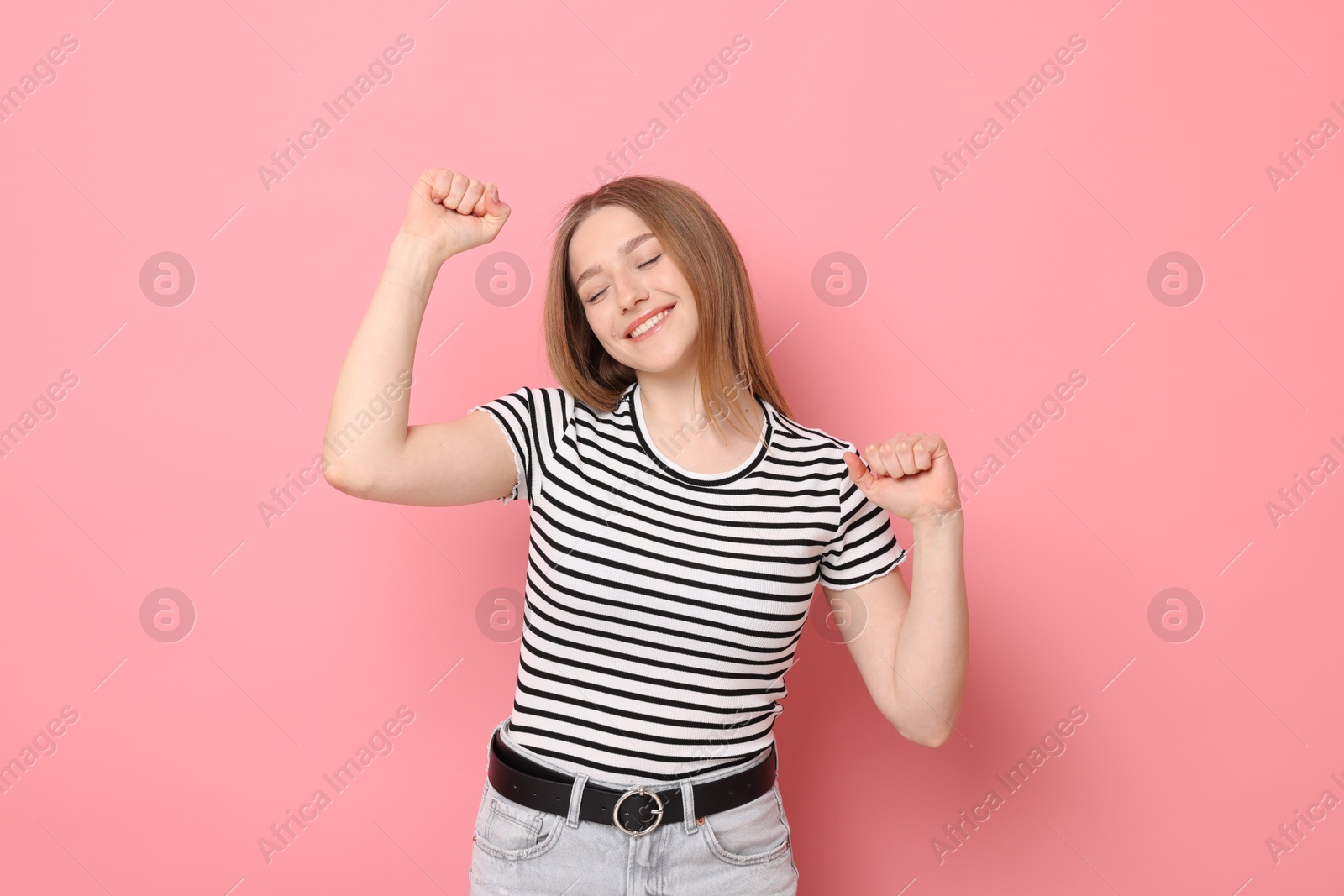 Portrait of smiling teenage girl on pink background Photo of Portrait of smiling teenage girl on pink background