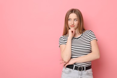 Photo of Portrait of thoughtful teenage girl on pink background. Space for text