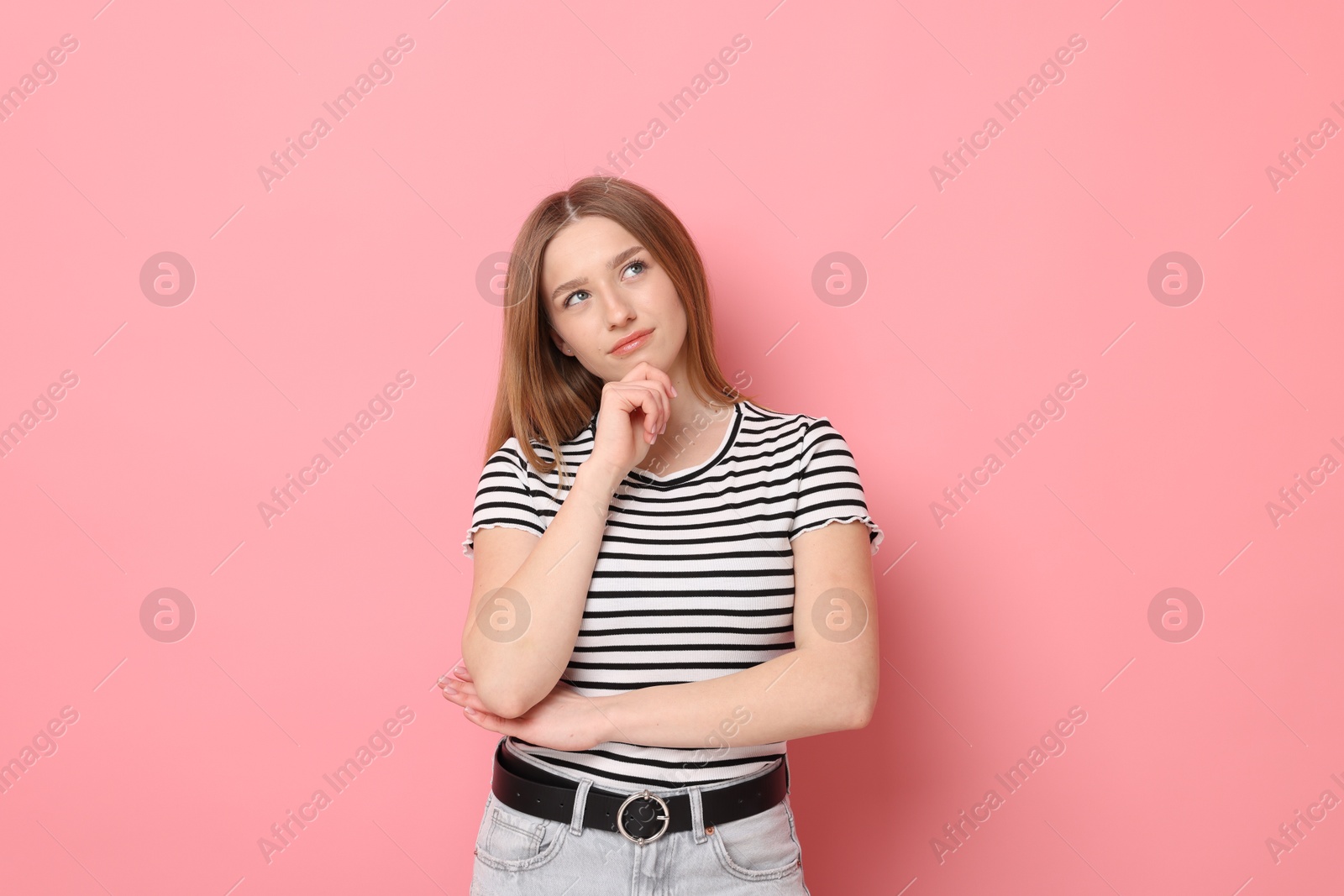 Portrait of thoughtful teenage girl on pink background Photo of Portrait of thoughtful teenage girl on pink background