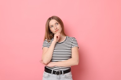 Photo of Portrait of thoughtful teenage girl on pink background