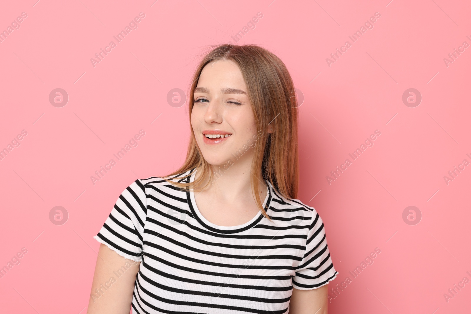 Portrait of smiling teenage girl on pink background Photo of Portrait of smiling teenage girl on pink background