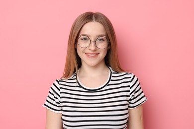 Photo of Portrait of smiling teenage girl on pink background