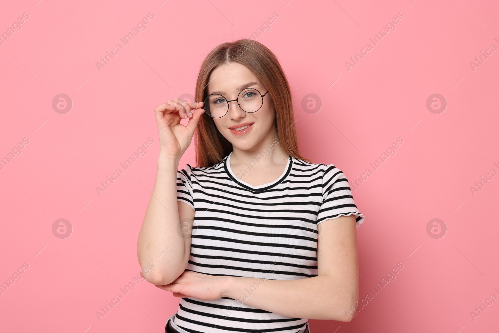Portrait of smiling teenage girl on pink background Photo of Portrait of smiling teenage girl on pink background