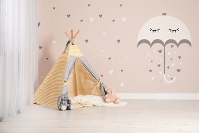 Image of Cozy children's room with play tent and cute wallpaper. Stylish playroom interior