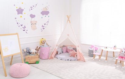 Image of Cozy playroom with toys, furniture and cute wallpaper. Stylish children's room interior
