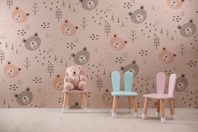 Image of Cozy playroom with toy, small chairs and cute wallpaper. Children's room interior