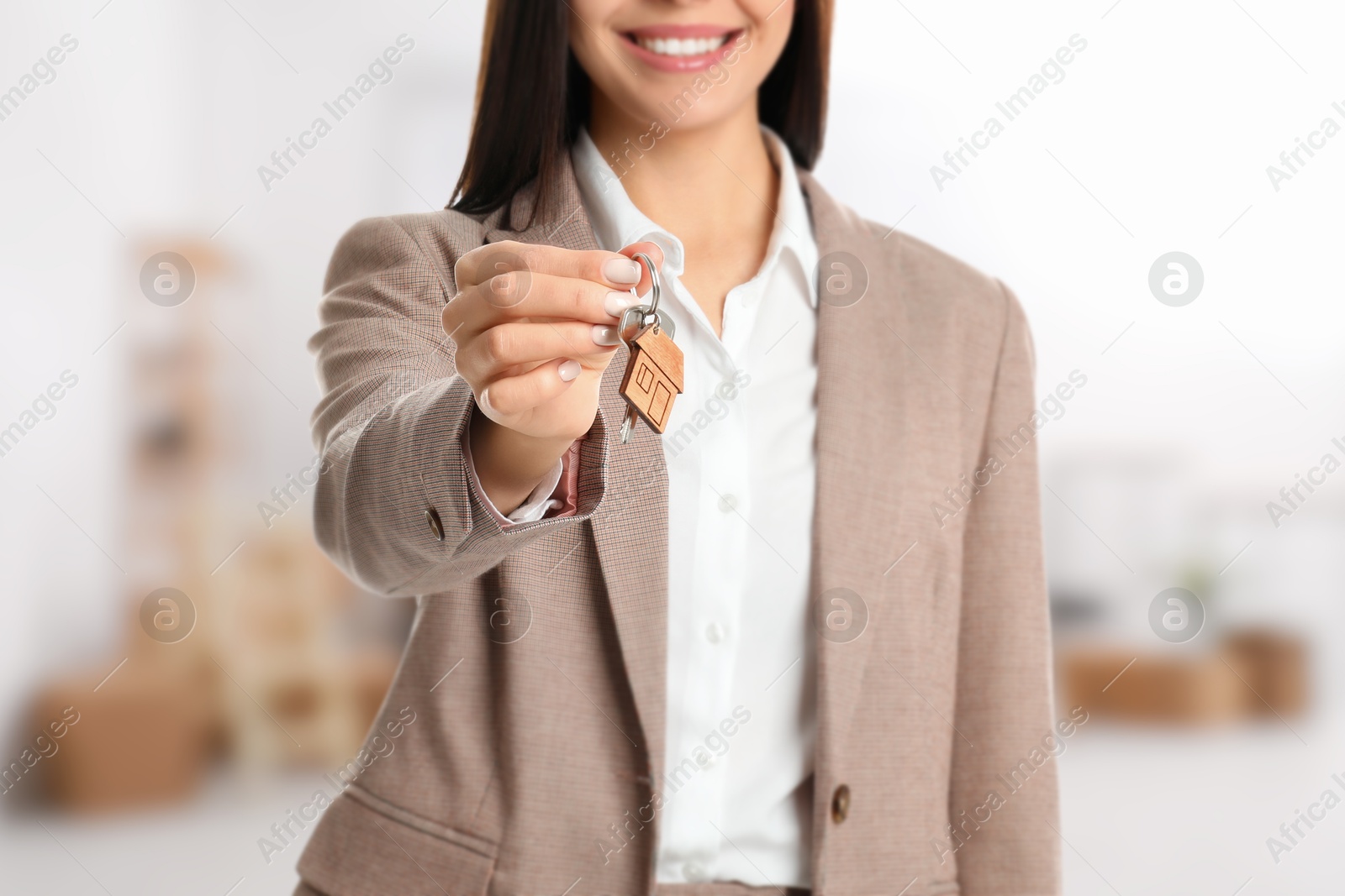 Real estate agent with house key indoors, closeup Image of Real estate agent with house key indoors, closeup