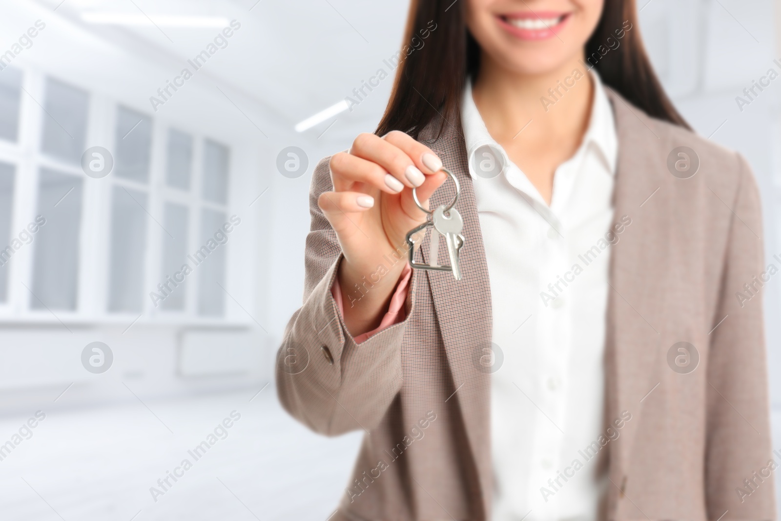 Real estate agent with house key in room, closeup Image of Real estate agent with house key in room, closeup