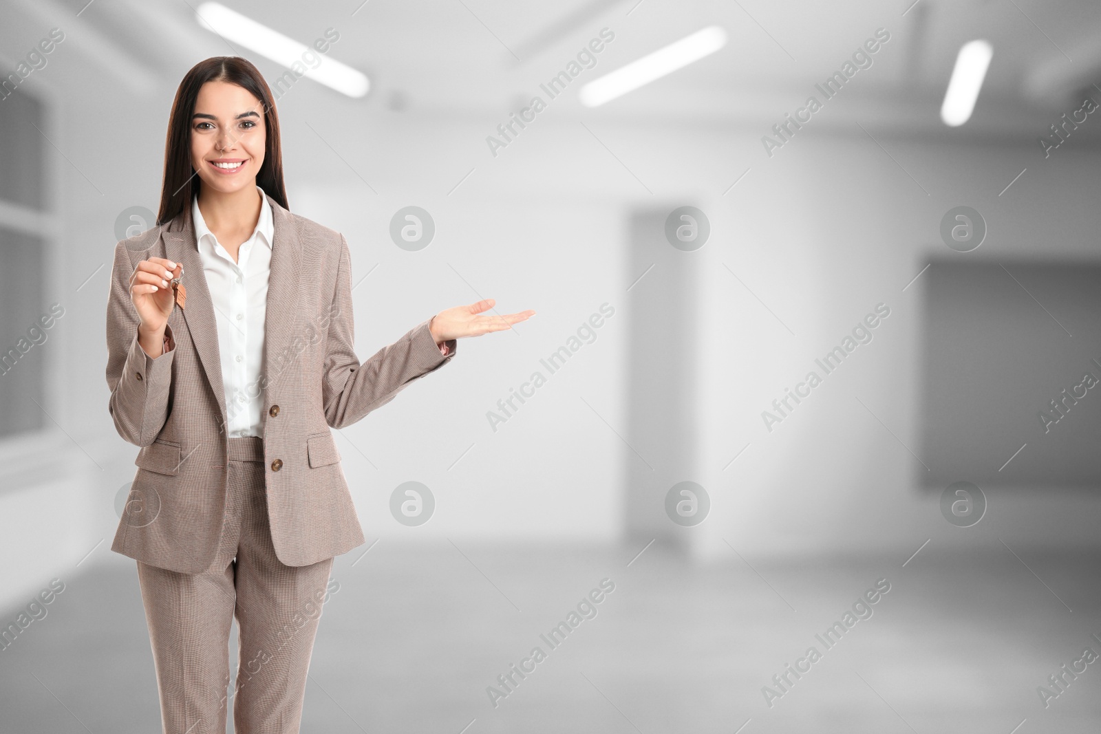Real estate agent with house key in apartment, space for text Image of Real estate agent with house key in apartment, space for text