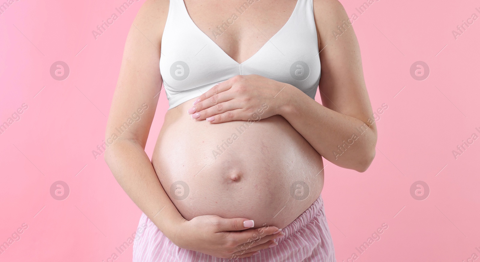 Pregnant woman on pink background, closeup view Photo of Pregnant woman on pink background, closeup view