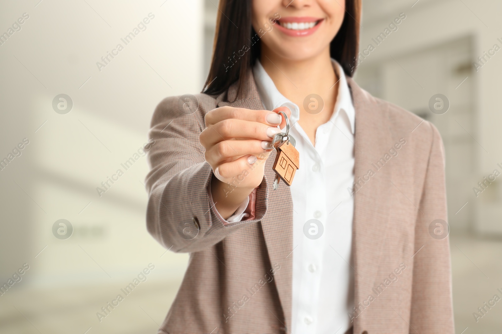 Real estate agent with house key indoors, closeup Image of Real estate agent with house key indoors, closeup