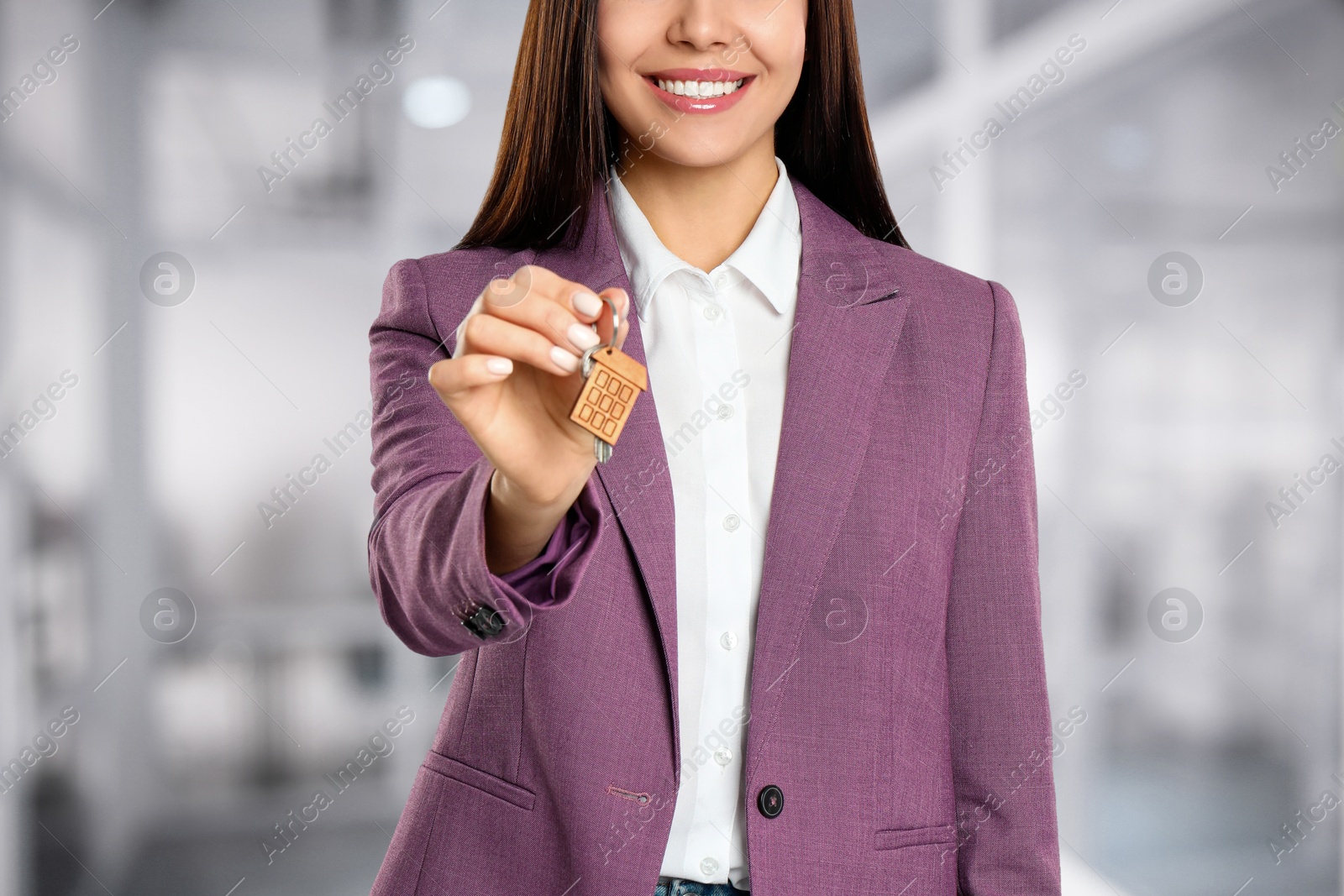 Real estate agent with house key indoors, closeup Image of Real estate agent with house key indoors, closeup