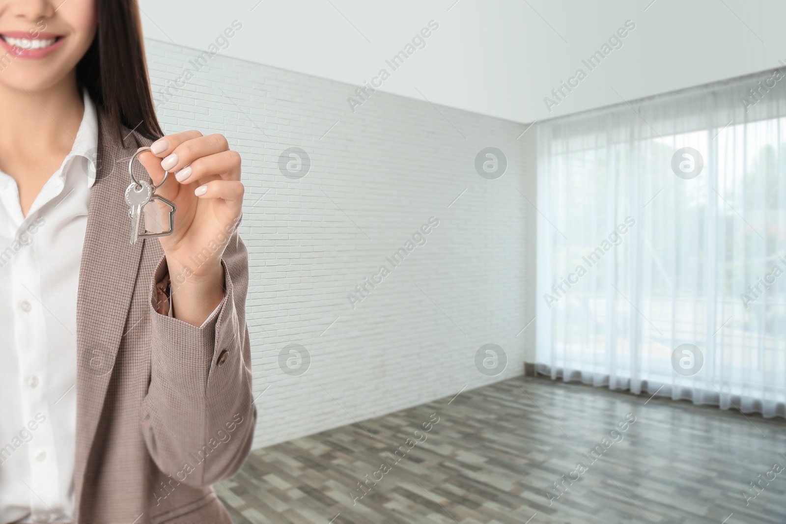 Real estate agent with house key in room, closeup. Space for text Image of Real estate agent with house key in room, closeup. Space for text