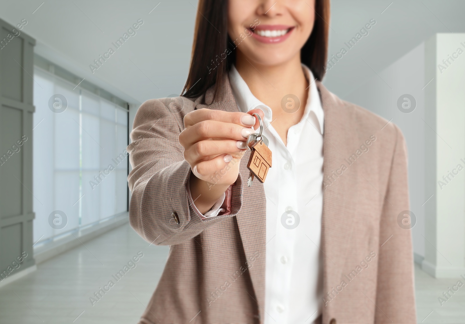 Real estate agent with house key indoors, closeup Image of Real estate agent with house key indoors, closeup