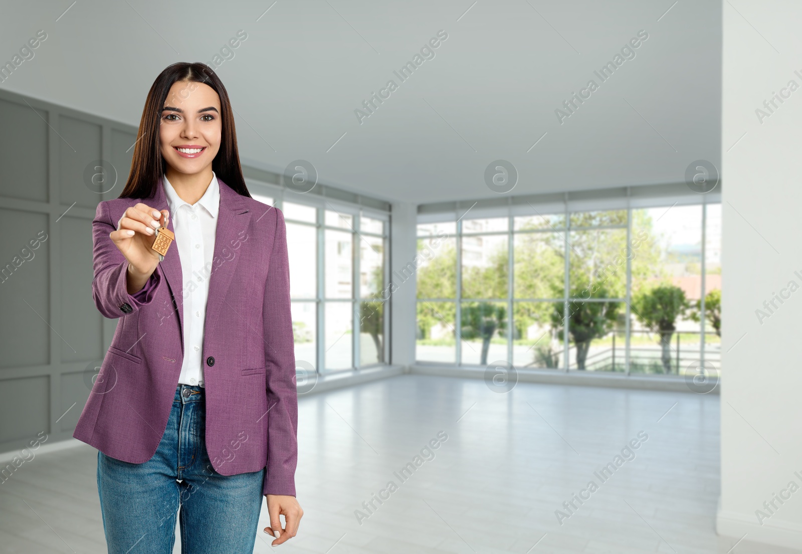 Real estate agent with house key in apartment, space for text Image of Real estate agent with house key in apartment, space for text