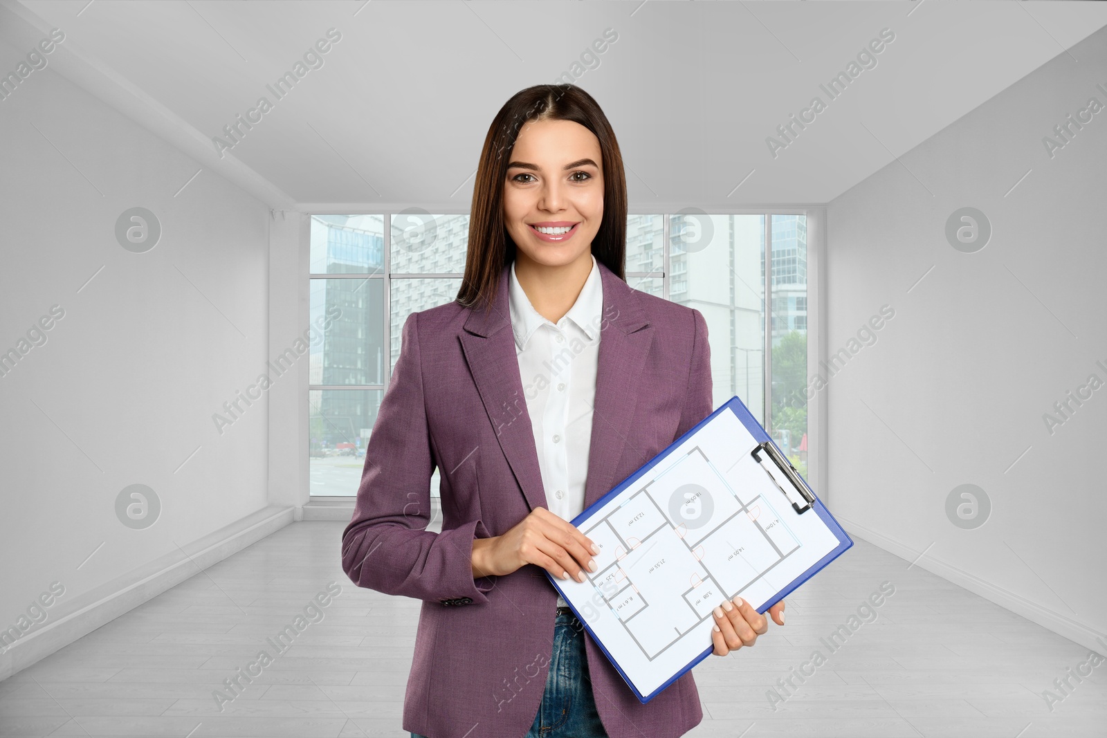 Real estate agent holding clipboard with house plan in room Image of Real estate agent holding clipboard with house plan in room
