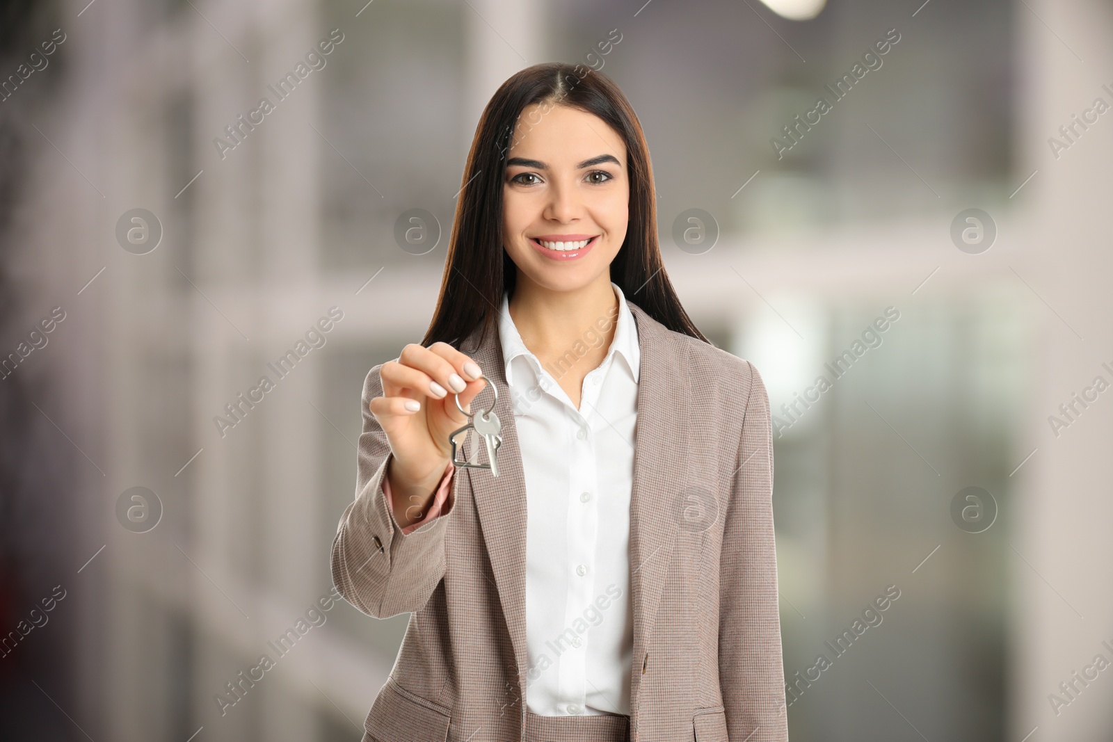 Real estate agent with house key indoors Image of Real estate agent with house key indoors