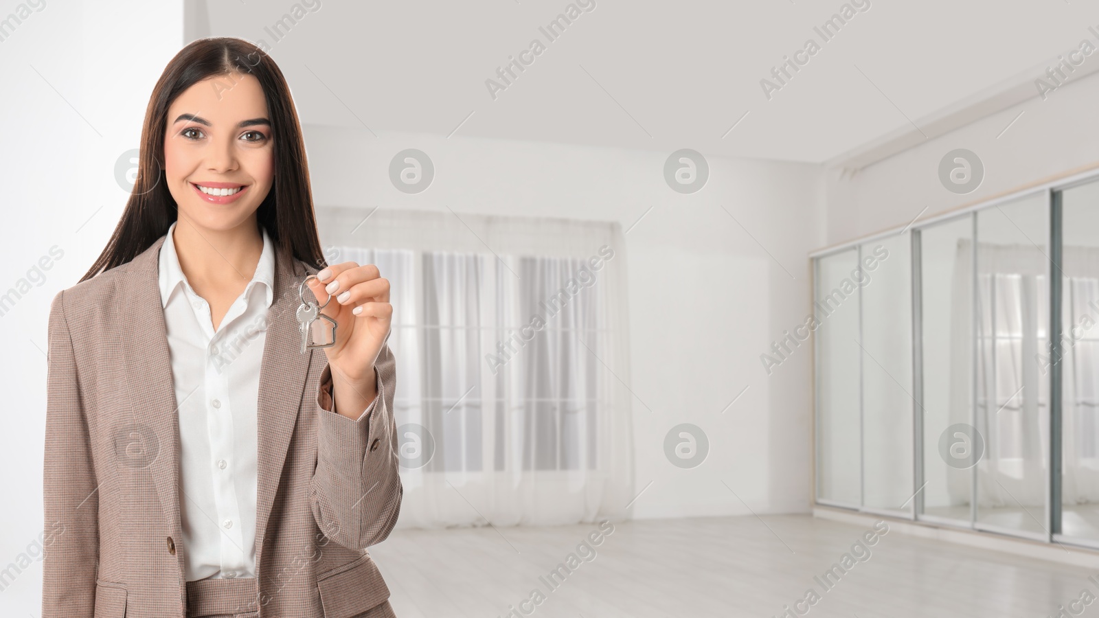 Real estate agent with house key in room. Banner with space for text Image of Real estate agent with house key in room. Banner with space for text