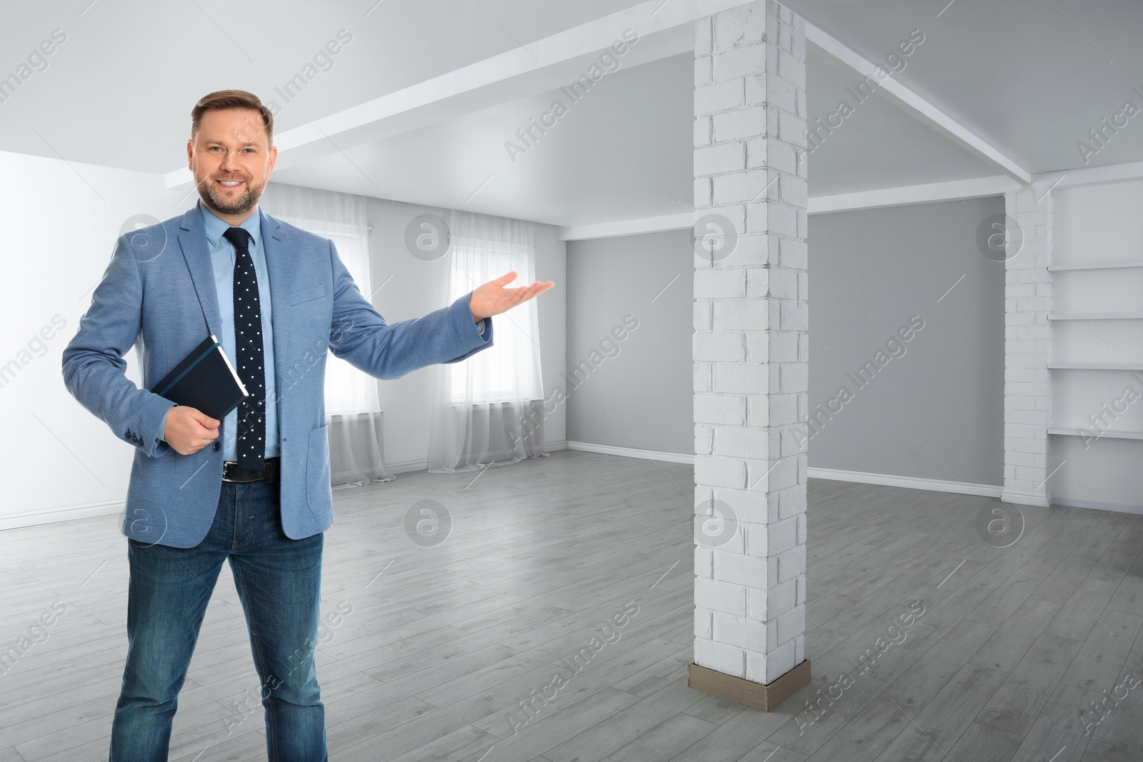 Real estate agent holding notebook in room Image of Real estate agent holding notebook in room