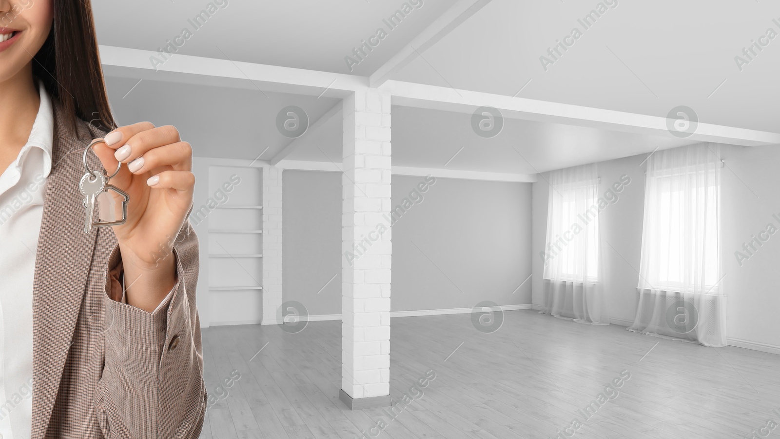 Real estate agent with house key in room, closeup. Banner with space for text Image of Real estate agent with house key in room, closeup. Banner with space for text