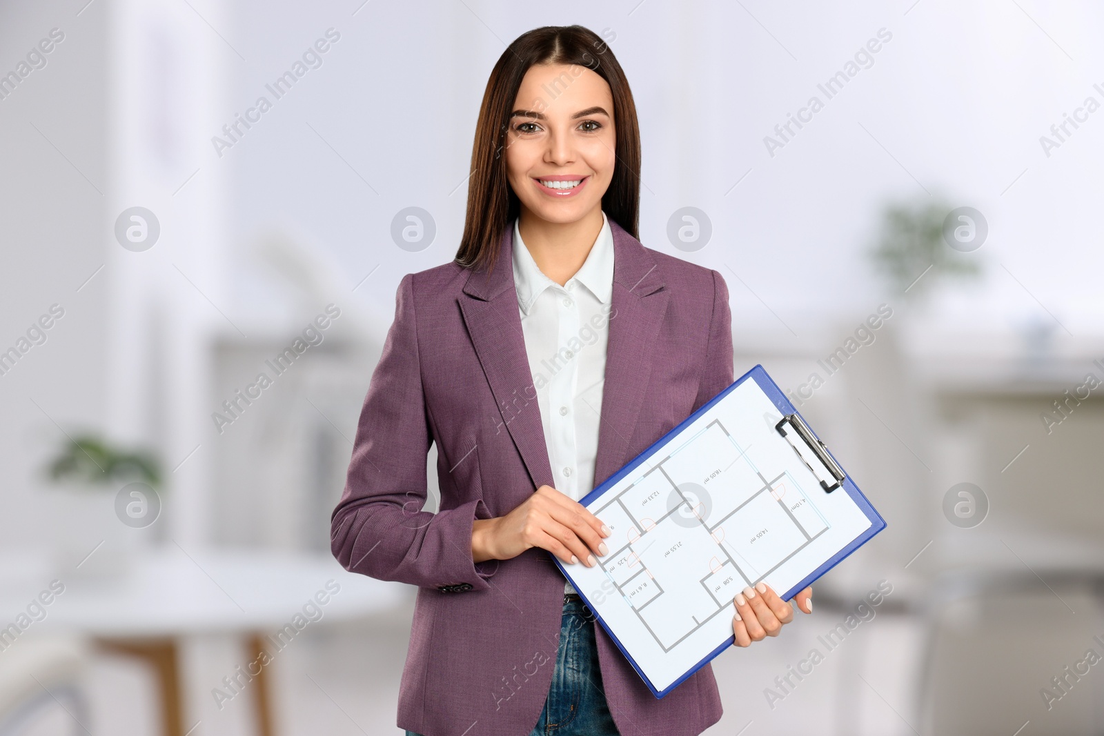 Real estate agent holding clipboard with house plan indoors Image of Real estate agent holding clipboard with house plan indoors