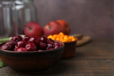 Photo of Tasty cherries and other fruits on wooden table, closeup. Space for text