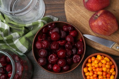 Photo of Tasty cherries, sea buckthorn berries and apples on wooden table, flat lay