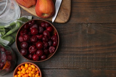 Photo of Tasty cherries, sea buckthorn berries and apples on wooden table, flat lay. Space for text