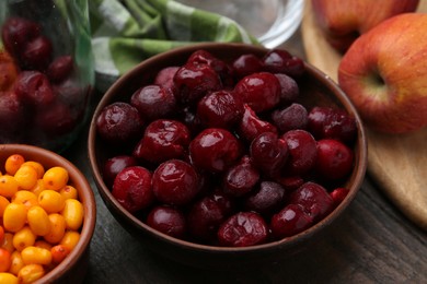 Photo of Tasty cherries, sea buckthorn berries and apples on wooden table, closeup