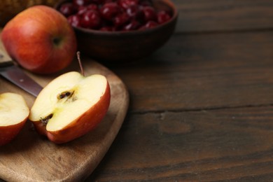 Photo of Apples and tasty cherries on wooden table, closeup. Space for text