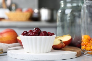Photo of Tasty cherries, apples and sea buckthorn berries on light grey table, closeup