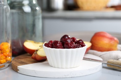 Photo of Tasty cherries, apples and sea buckthorn berries on light grey table, closeup