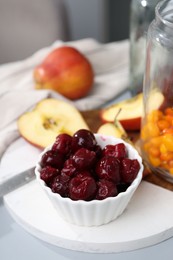Photo of Tasty cherries, apples and sea buckthorn berries on light grey table, closeup
