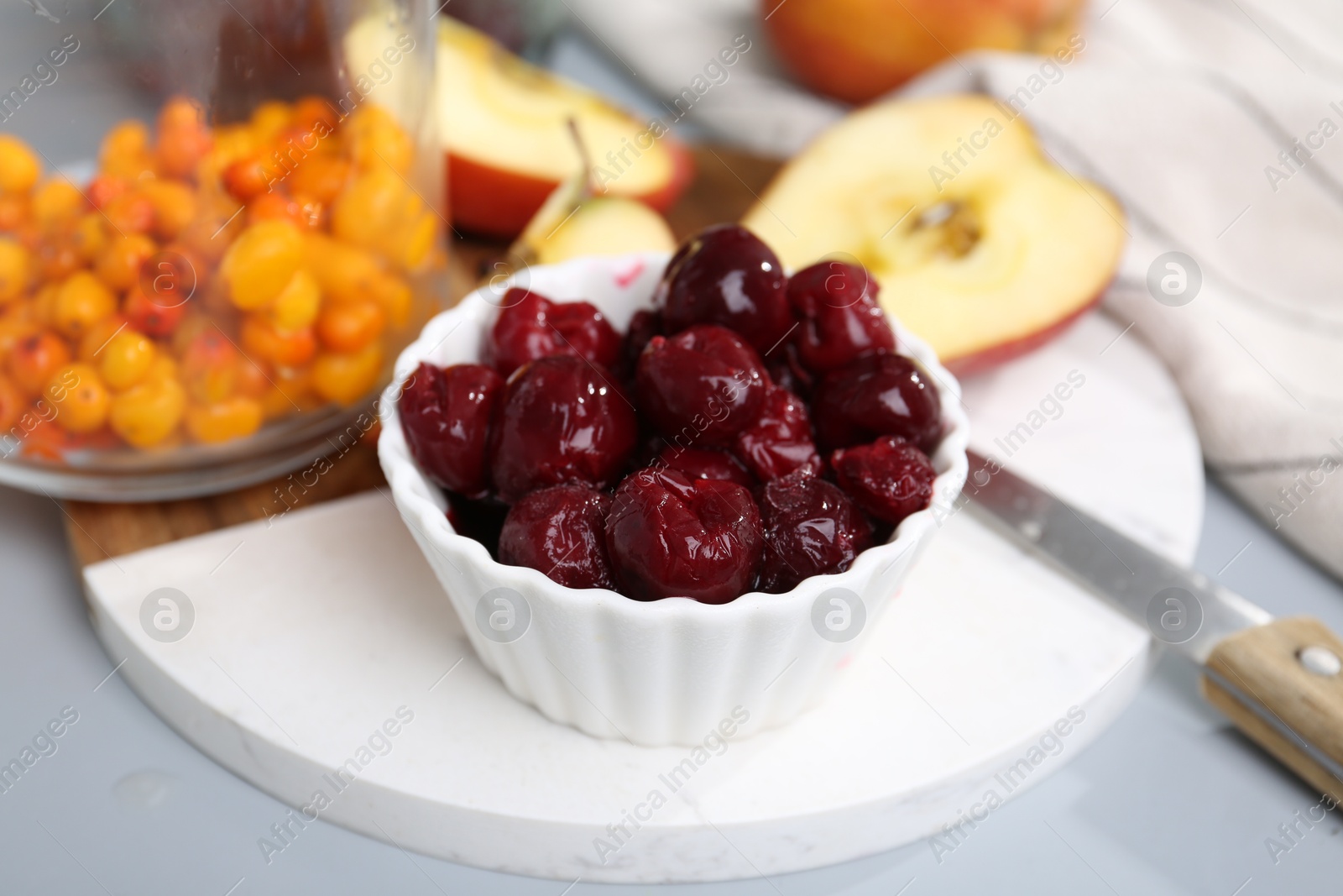 Tasty cherries, apples and sea buckthorn berries on light grey table, closeup Photo of Tasty cherries, apples and sea buckthorn berries on light grey table, closeup