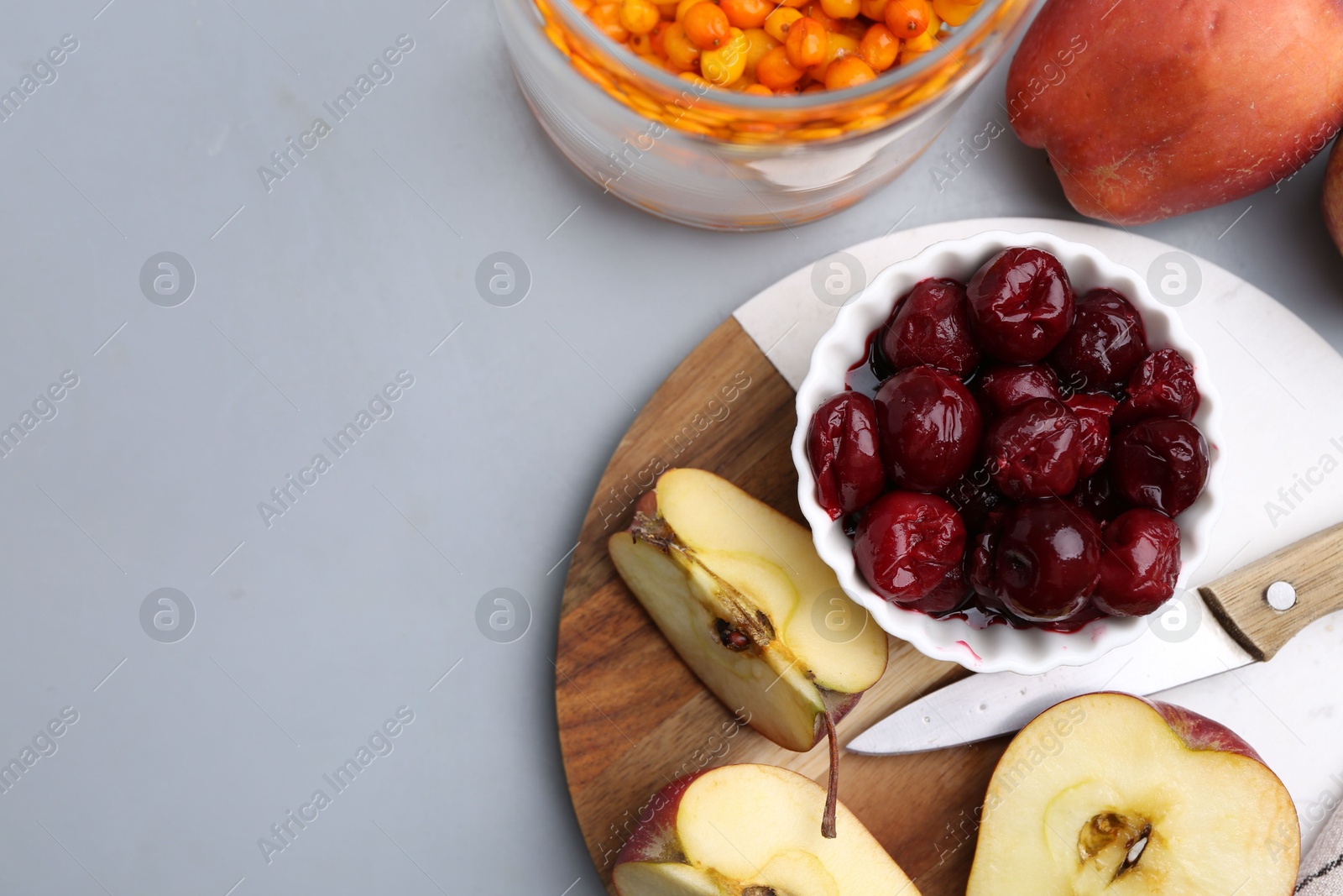 Tasty cherries, apples and sea buckthorn berries on light grey table, flat lay. Space for text Photo of Tasty cherries, apples and sea buckthorn berries on light grey table, flat lay. Space for text
