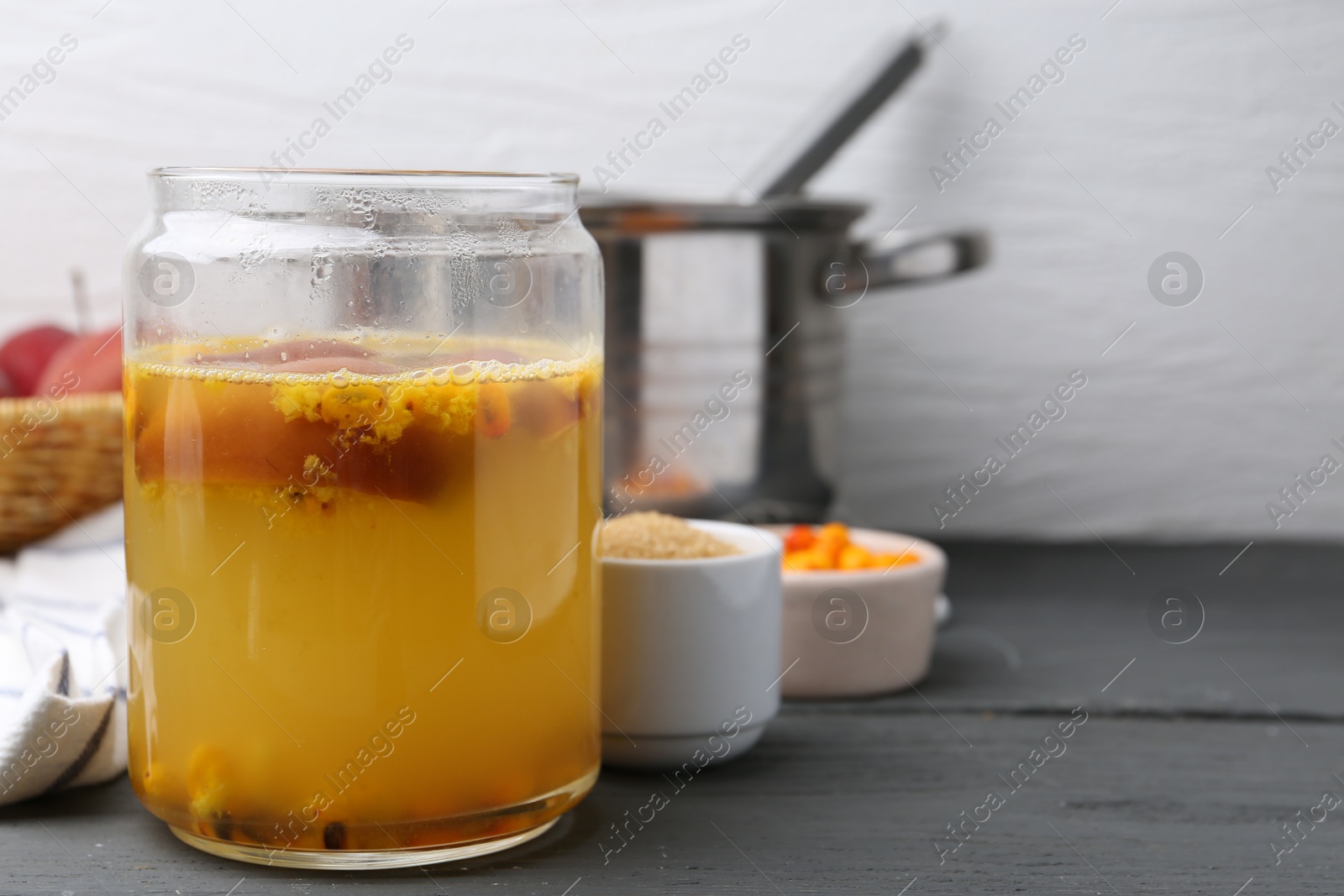 Tasty compot in glass jar and ingredients on grey wooden table, closeup. Space for text Photo of Tasty compot in glass jar and ingredients on grey wooden table, closeup. Space for text