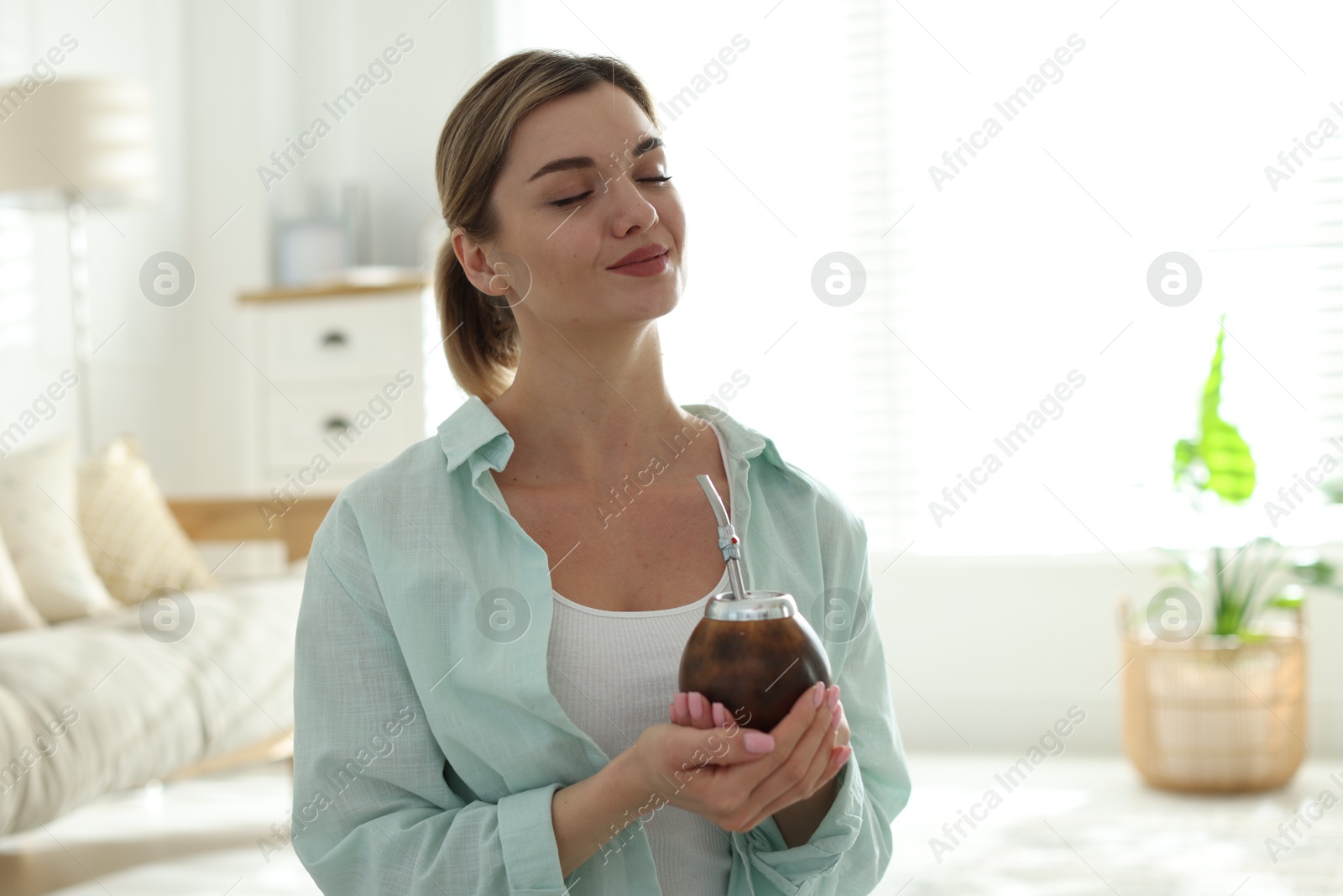 Woman with traditional yerba mate tea at home Photo of Woman with traditional yerba mate tea at home