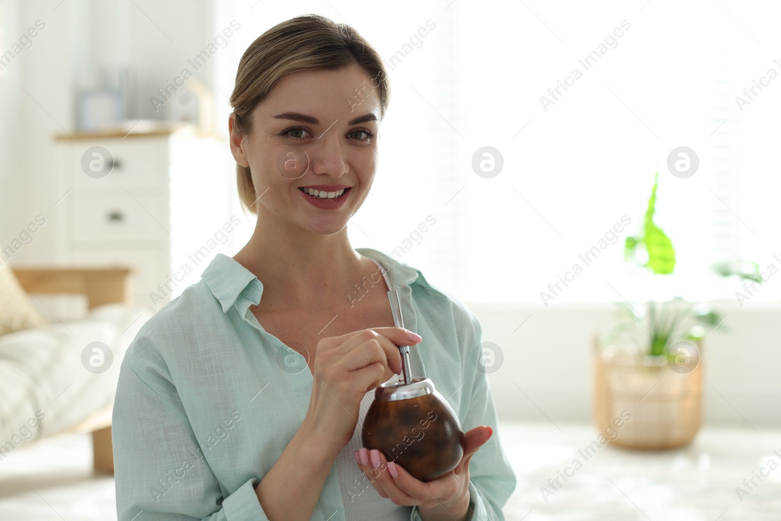 Woman with traditional yerba mate tea at home, space for text Photo of Woman with traditional yerba mate tea at home, space for text