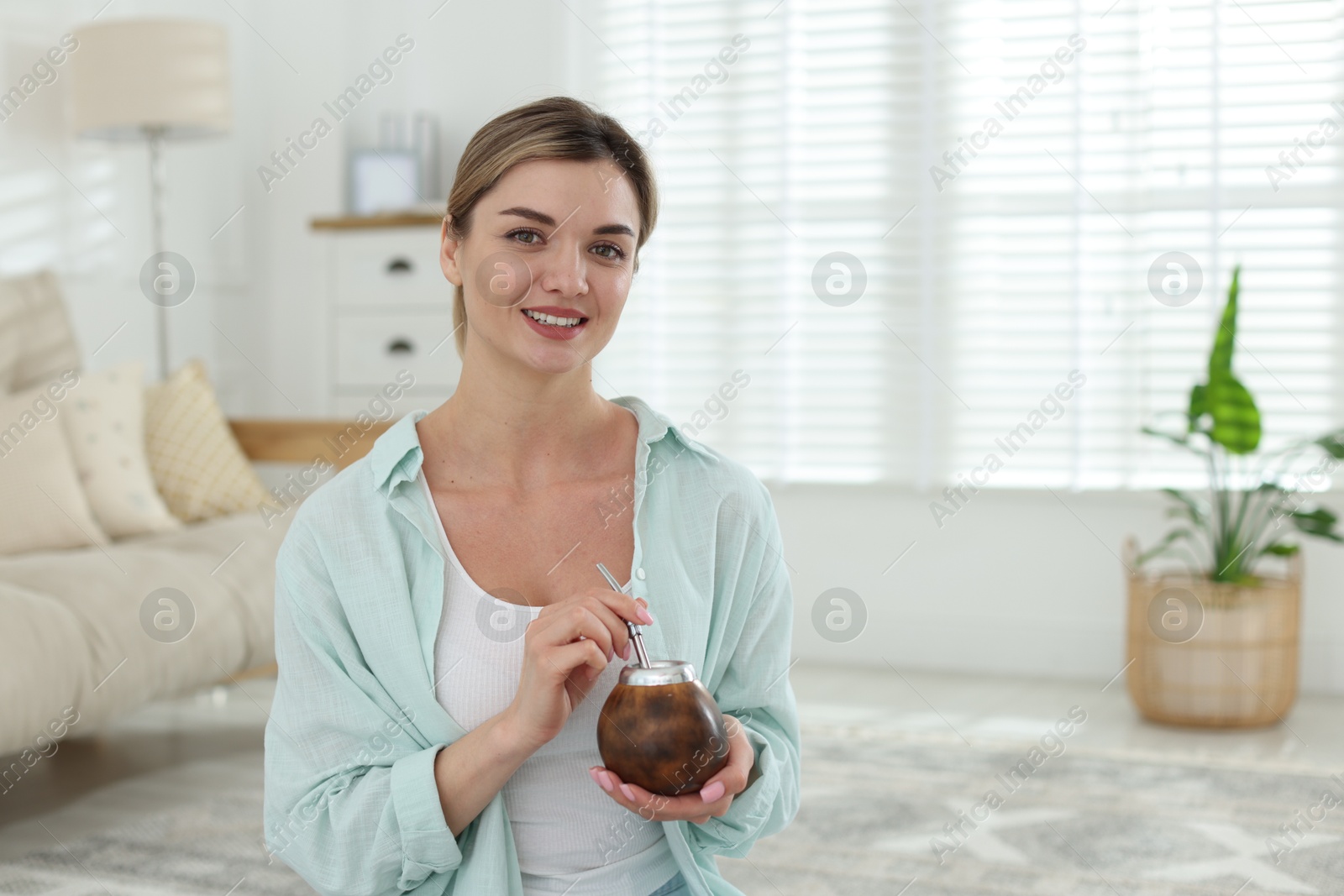 Woman with traditional yerba mate tea at home, space for text Photo of Woman with traditional yerba mate tea at home, space for text